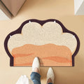 Paw-shaped, anti-slip cat litter mat in beige and orange with a dark brown border. Textured surface traps loose litter.