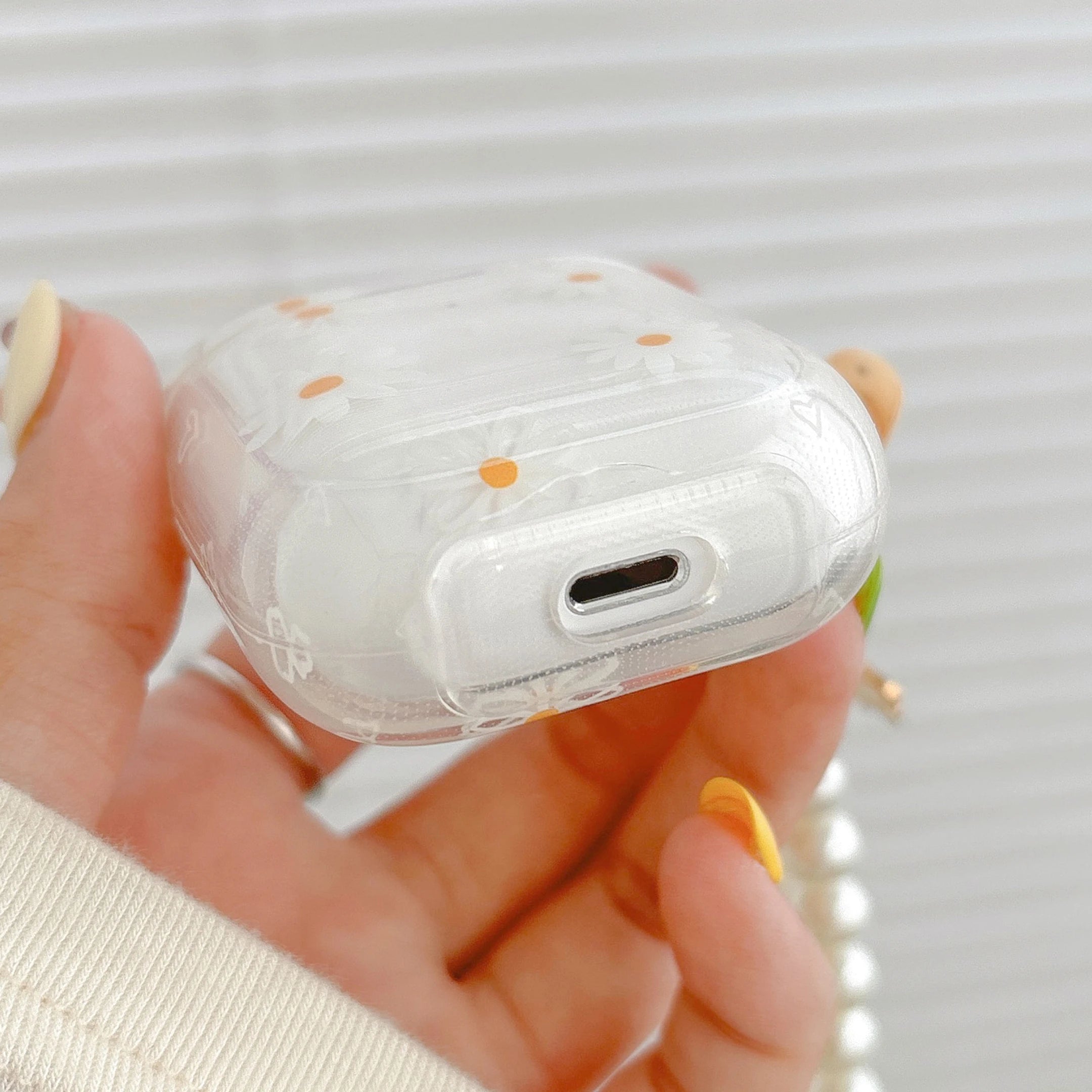 Clear, protective AirPod case featuring a daisy floral pattern, designed for Apple AirPods.