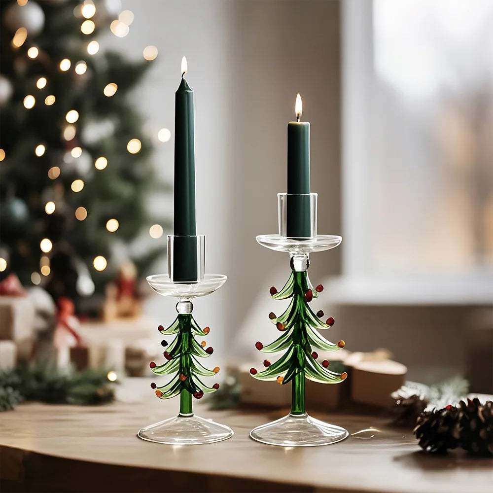 Two green glass Christmas tree candlestick holders with lit dark green taper candles.