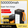 Black portable power bank with orange carry strap, LED display, multiple ports, and built-in flashlight panel.