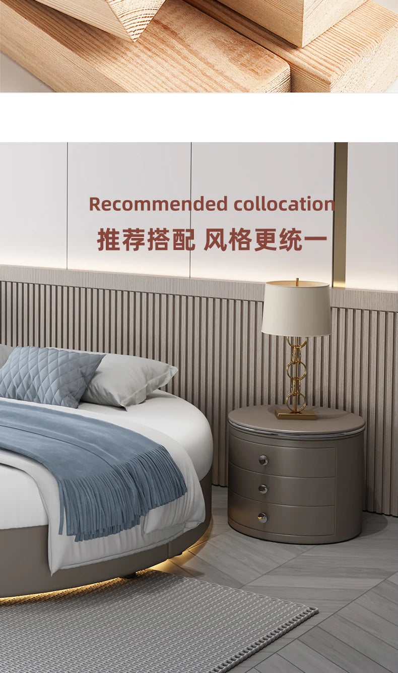 A modern minimalist curved double bed frame in a neutral tone, paired with a matching round three-drawer bedside table.