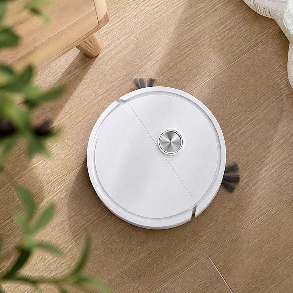 Overhead shot of a white robotic vacuum cleaner with side brushes on a light wood floor.