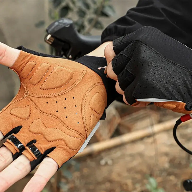 Tan and black fingerless cycling gloves with padded palms and breathable perforated fabric.