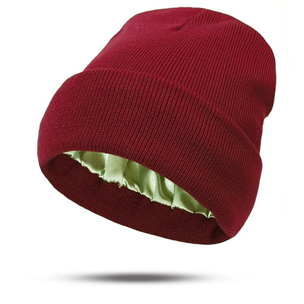 Deep red knitted winter beanie with a folded cuff and smooth, sage green satin lining.