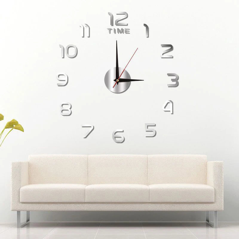 Large DIY silver acrylic wall clock with individual 3D numbers, mounted above a neutral-toned sofa in a living room.