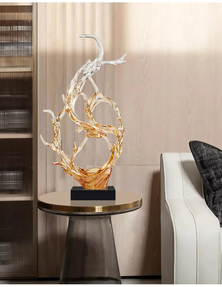 Abstract amber and clear resin sculpture on a black base, featuring fluid, branch-like shapes on a round side table.
