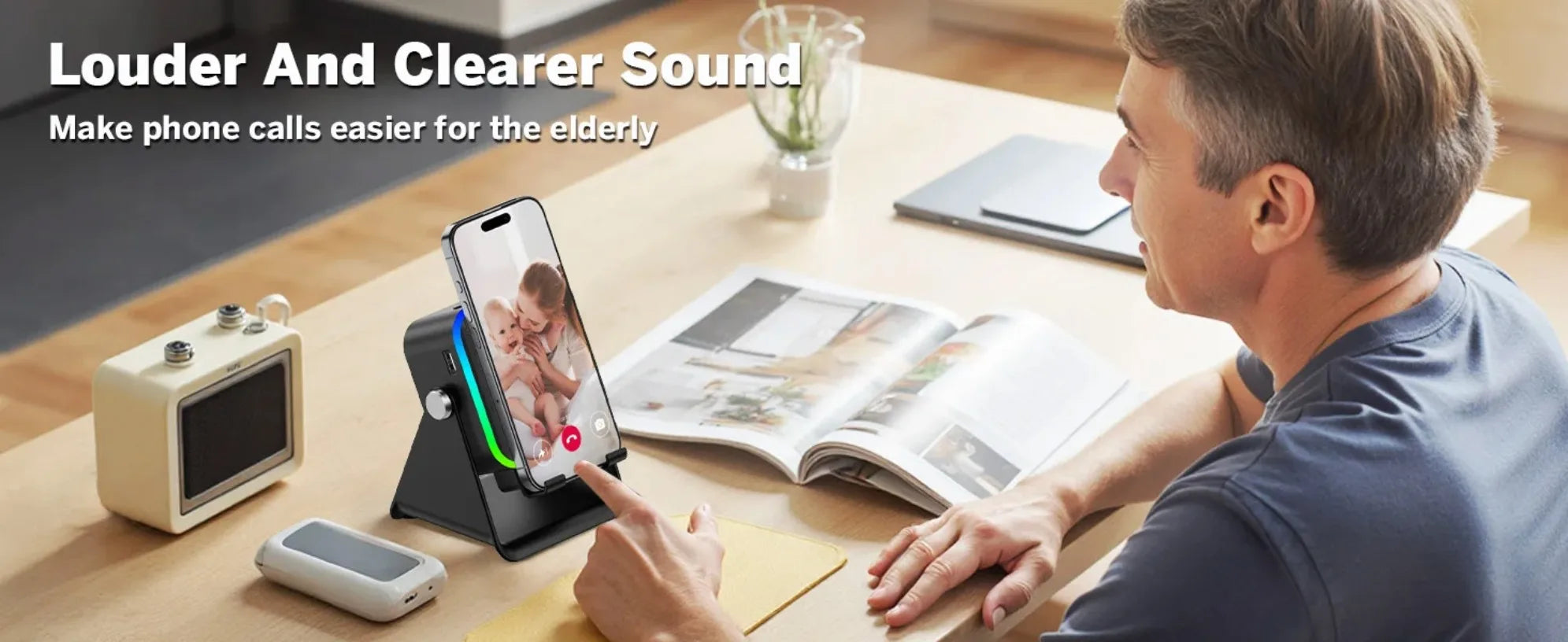 A black portable Bluetooth speaker with a built-in phone stand and glowing RGB light strip, shown in use on a desk.