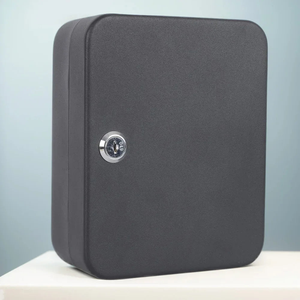 Matte black metal wall-mounted key cabinet with a silver keyed cylinder lock on the front.