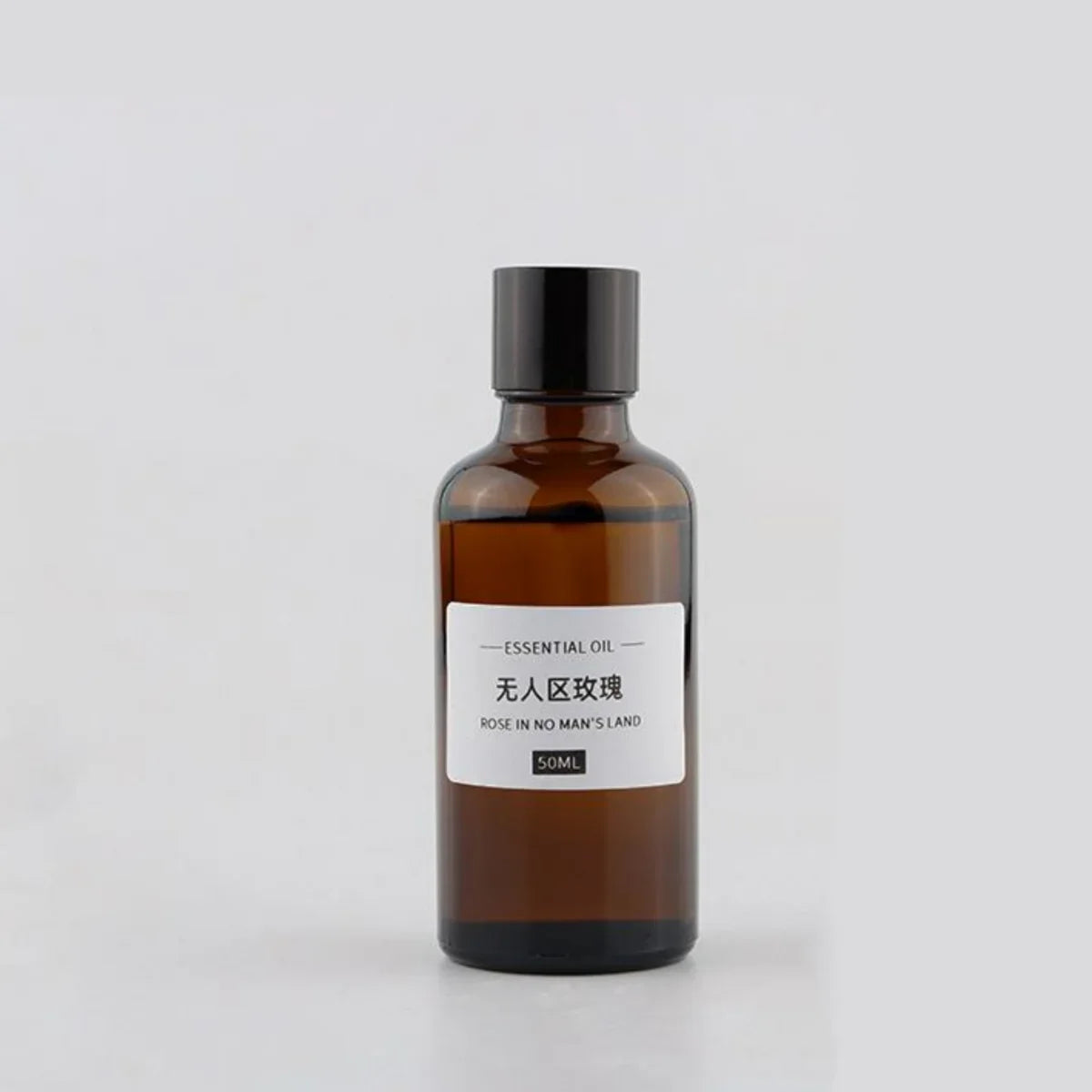 50ml amber glass bottle of rose essential oil with a simple white minimalist label and black screw cap.