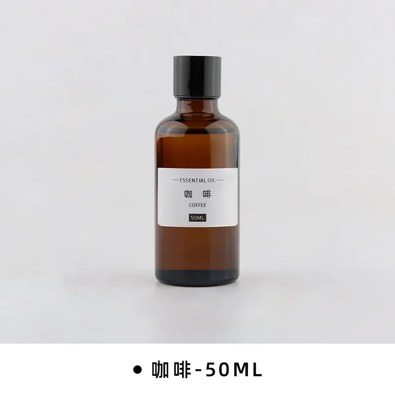 50ml amber glass bottle of coffee essential oil with a black screw cap and simple white label on a white background.