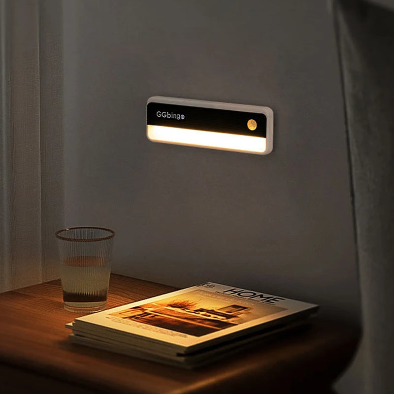 Rectangular white and black plastic motion sensor LED night light mounted on a wall.