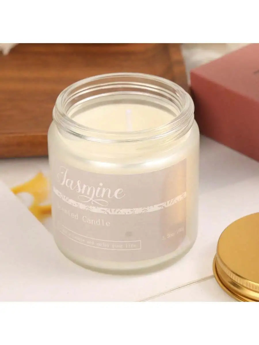 Jasmine-scented candle in a clear glass jar with a minimalist label and a separate gold metal lid.