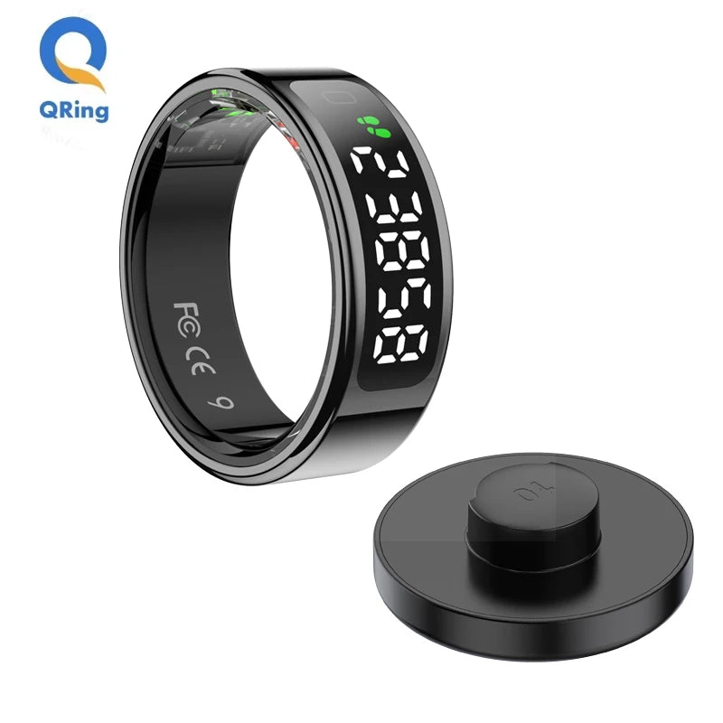 Sleek black smart fitness ring with a digital touch display, shown alongside its matching magnetic charging base.