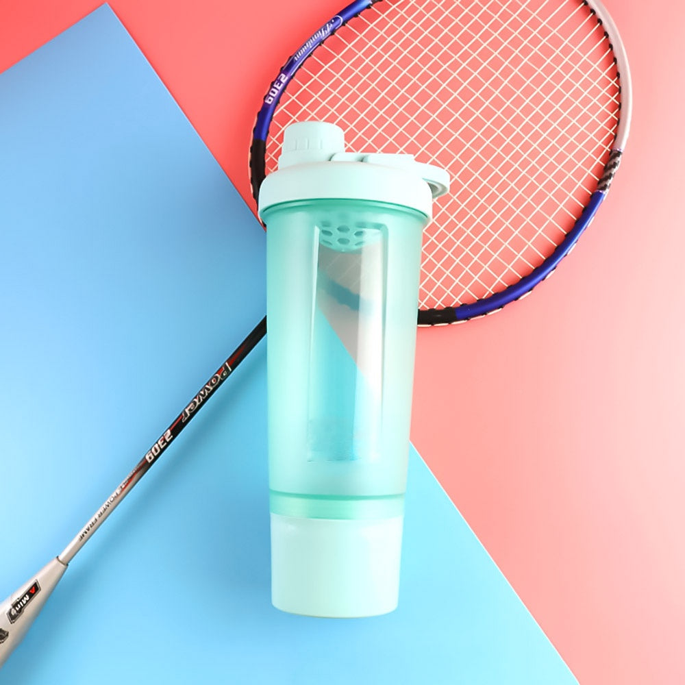 Light mint green plastic shaker bottle on a blue and pink background with a badminton racket.