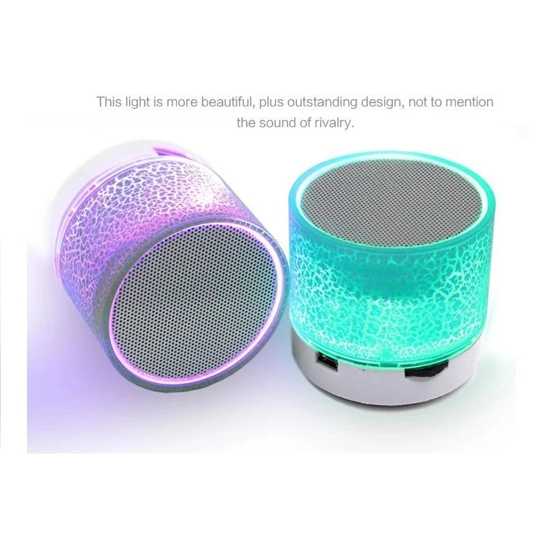 Two portable mini wireless speakers with glowing, colour-changing cracked-effect LED lights and silver speaker grilles.