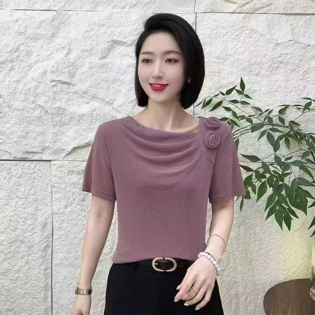 Mauve, short-sleeved blouse with a cowl neckline and floral shoulder detail, featuring a textured, elegant design.