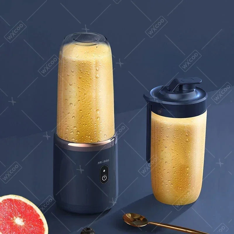 A dark blue portable electric blender with a clear cup containing yellow smoothie, with an extra lid and sliced fruit.