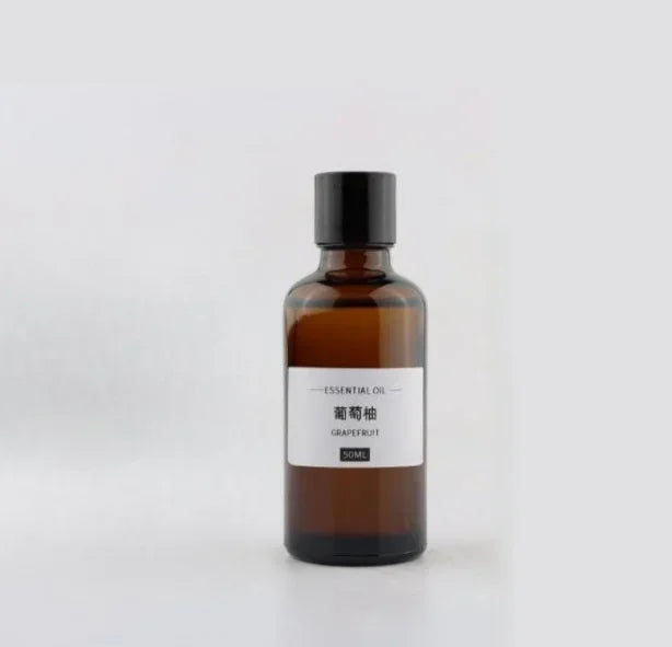 Amber glass 50ml essential oil bottle with a black cap and white label marked "Grapefruit".