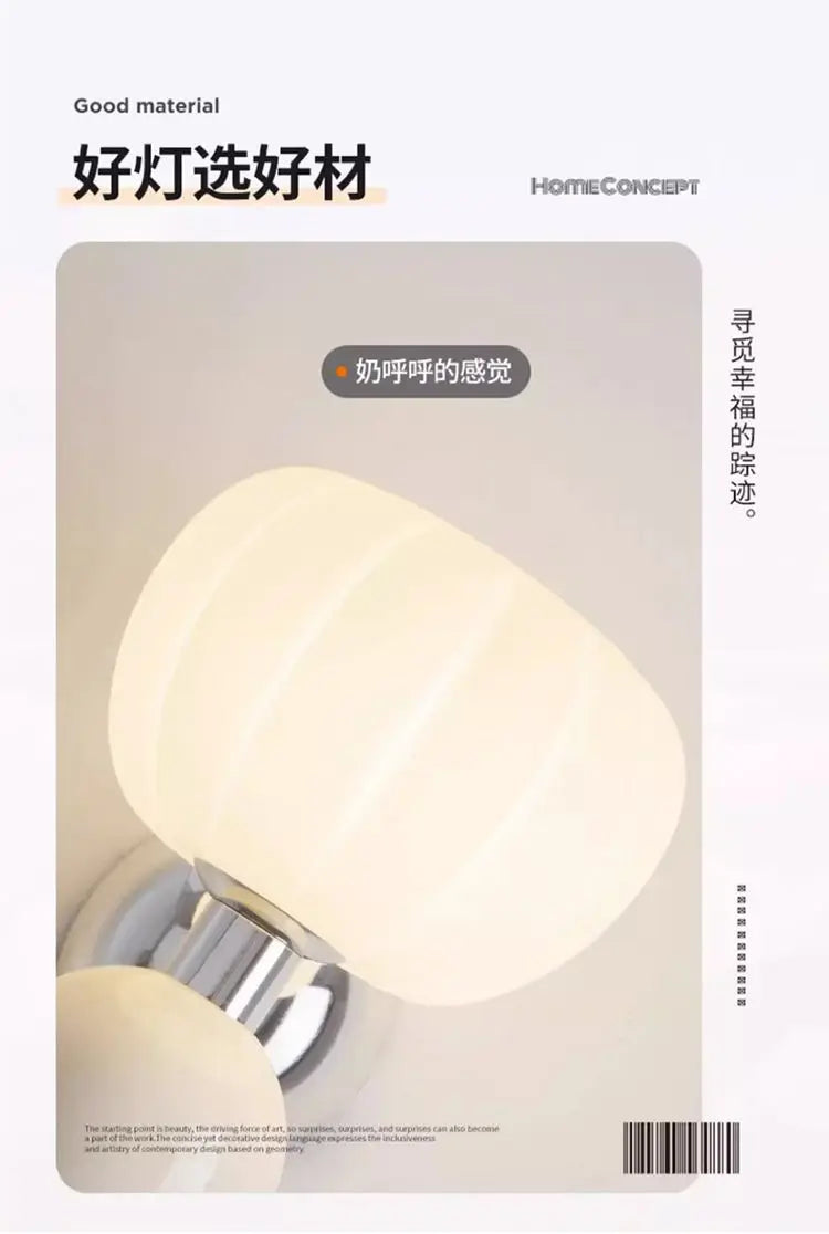 Cream-coloured, double-head wall lamp with soft, glowing rounded glass shades and a polished silver-tone base.