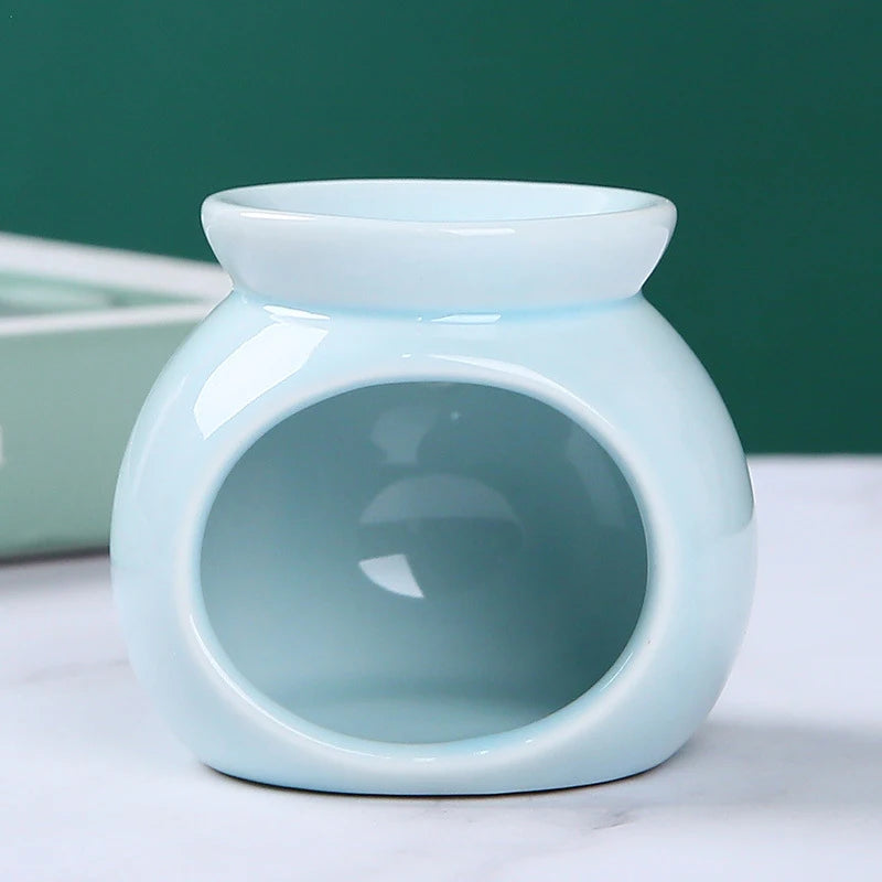 Glossy, pale blue ceramic wax melt burner with a round, modern shape and a wide opening for a tea light candle.