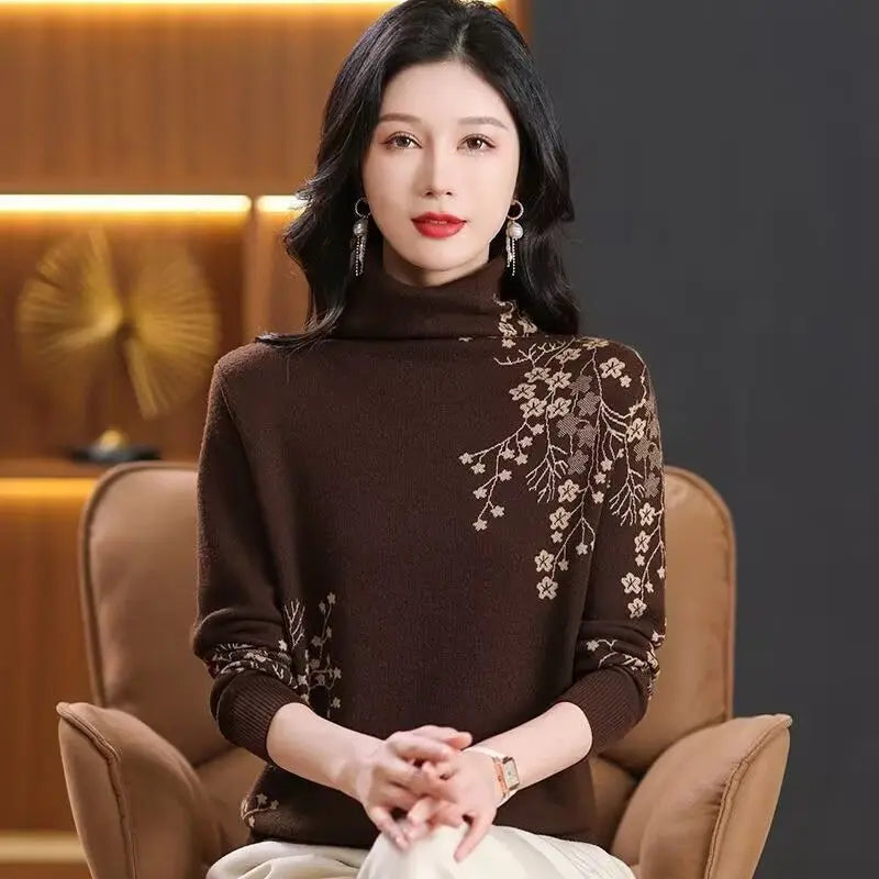 A woman wearing a brown turtleneck jumper featuring delicate cream floral embroidery on the shoulder and sleeve.