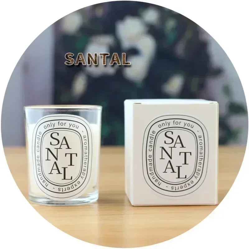 Santal scented candle in a clear glass jar, with a white presentation box featuring a classic oval label.