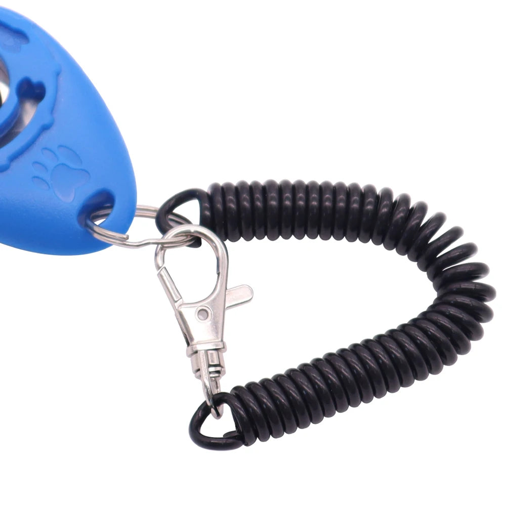 Blue dog training clicker with embossed paw print, attached to a black coiled wrist strap and silver metal clip.