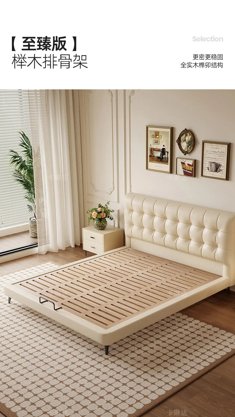 Minimalist cream storage bed with a tufted headboard and natural wooden slatted base in a bright, modern bedroom.