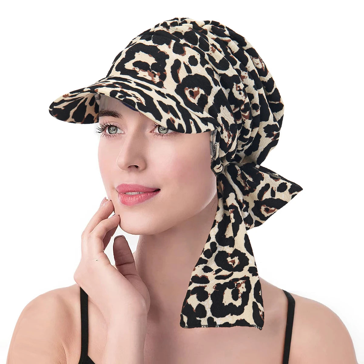 Elegant leopard print turban hat featuring a structured front brim and a decorative tie-knot detail at the back.