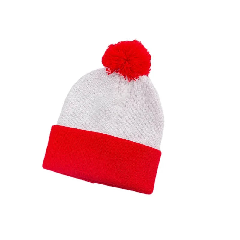 A white knitted beanie hat with a thick red ribbed cuff and a red pom-pom on top.