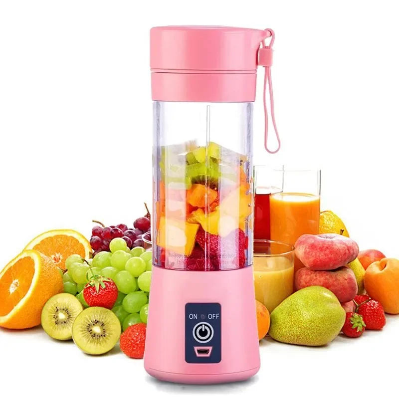 Portable pink electric blender with a clear mixing cup, surrounded by various fresh fruits.