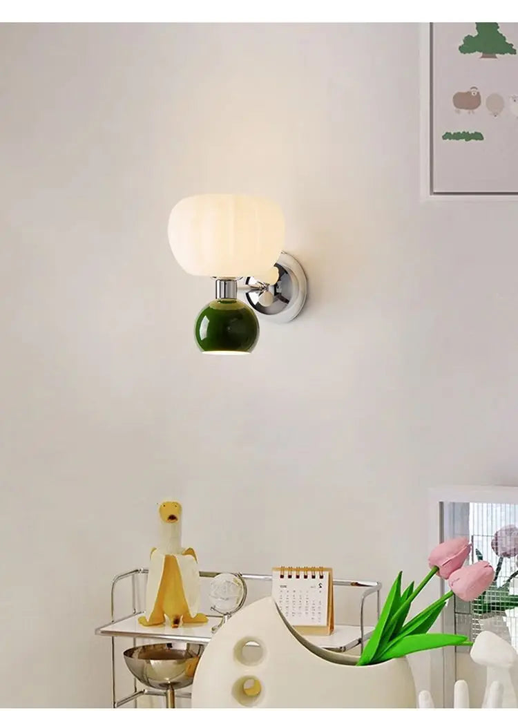 Cream-style wall lamp with a green ceramic base, chrome detailing, and a white, pumpkin-shaped glass shade.