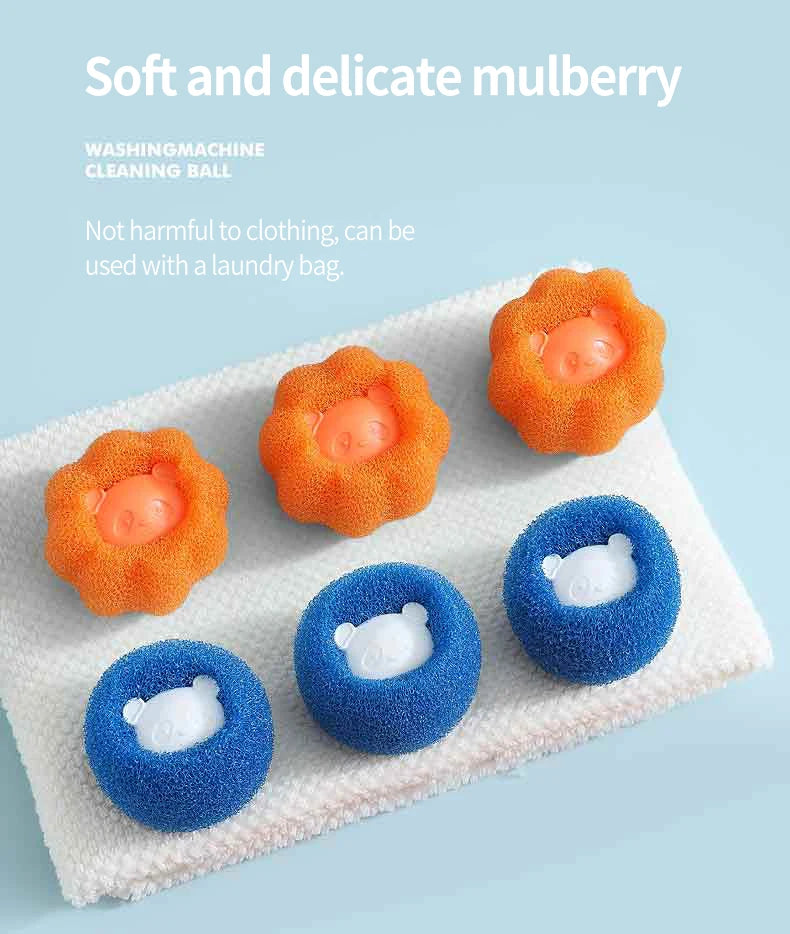 Three orange and three blue sponge laundry cleaning balls with cute bear faces, resting on a white towel.