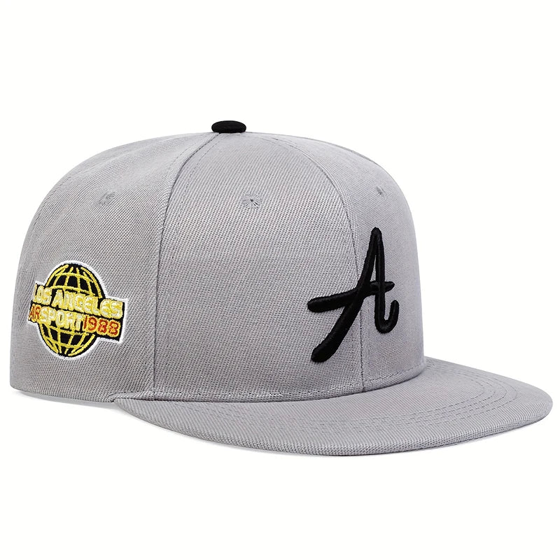 Grey baseball cap with a black Gothic letter 'A' on the front and a yellow Los Angeles globe patch on the side.