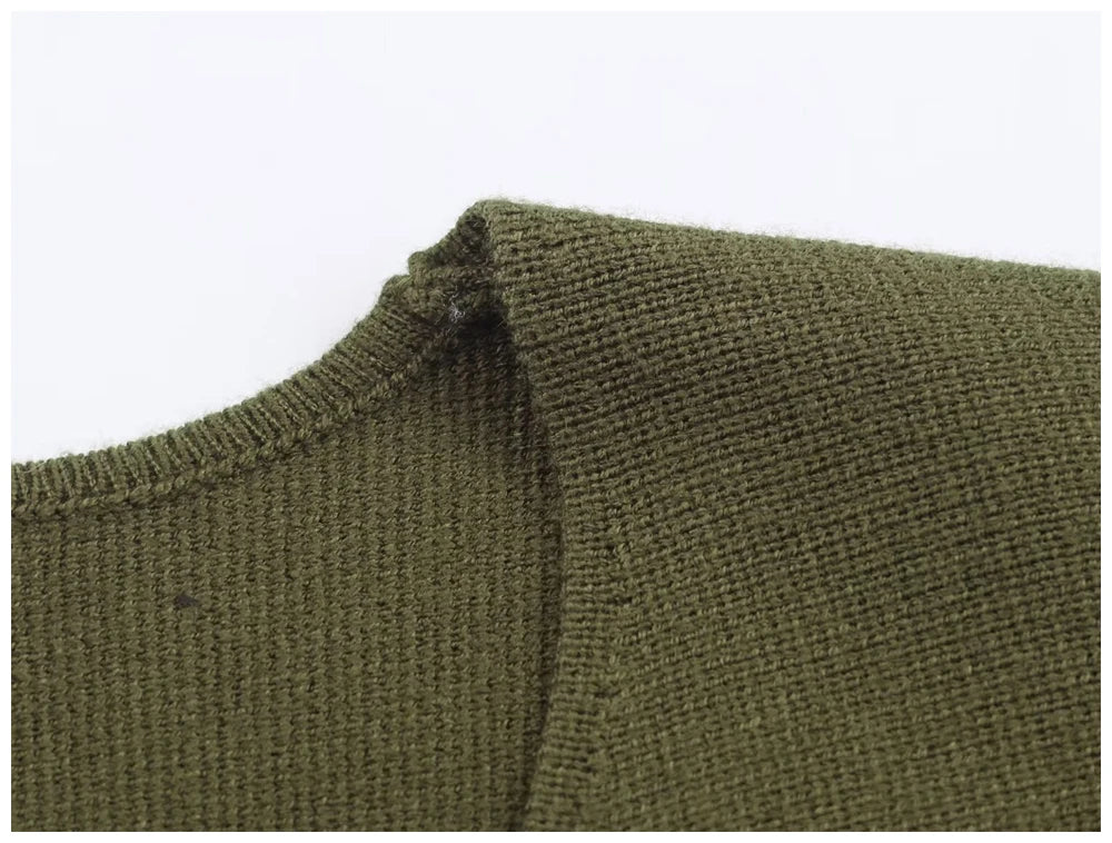 Close-up of an olive green knitted jumper featuring a round neckline with ribbed trim detail.