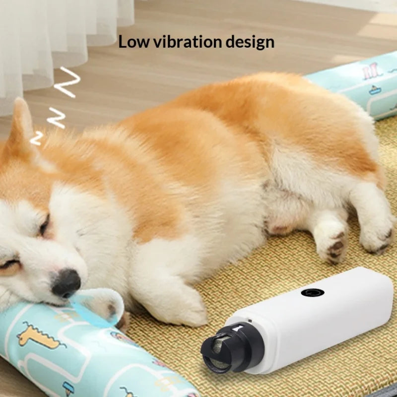White, handheld electric pet nail grinder with an LED light and low-vibration design, placed beside a sleeping dog.