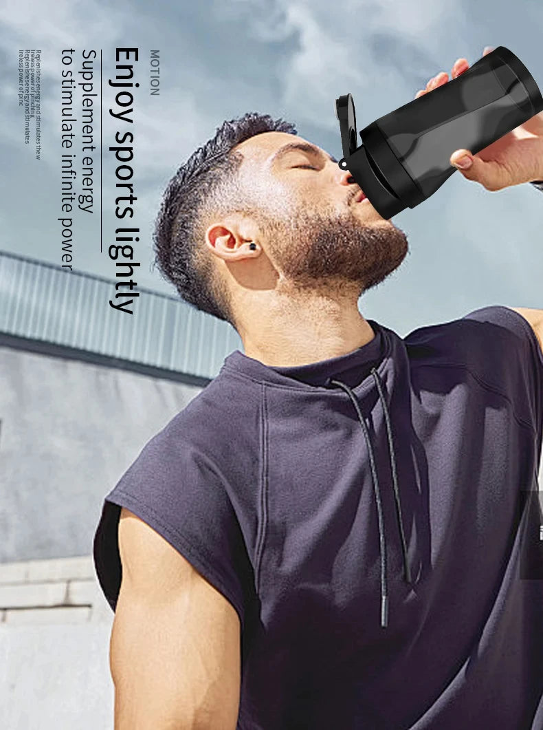 A man drinking from a sleek, black sports shaker bottle against an outdoor background.