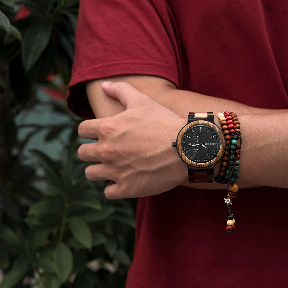 BOBO BIRD round wooden watch with a black dial and date display, worn with beaded bracelets.