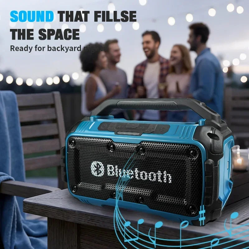 Rugged, blue and black portable Bluetooth speaker with a top carry handle, sitting on a wooden outdoor table.