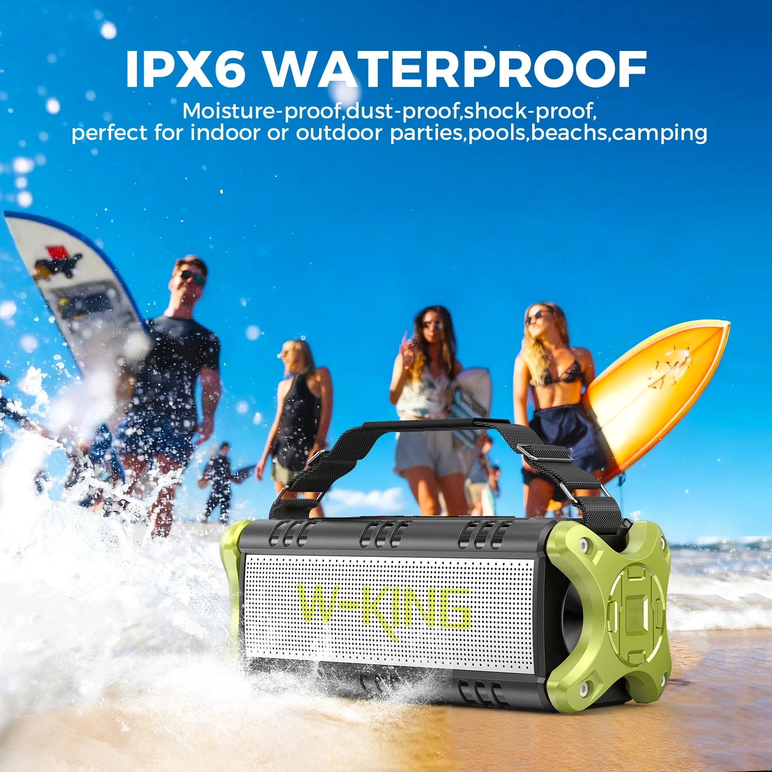 Rugged black and olive green waterproof Bluetooth speaker with a carry strap on a sandy beach.