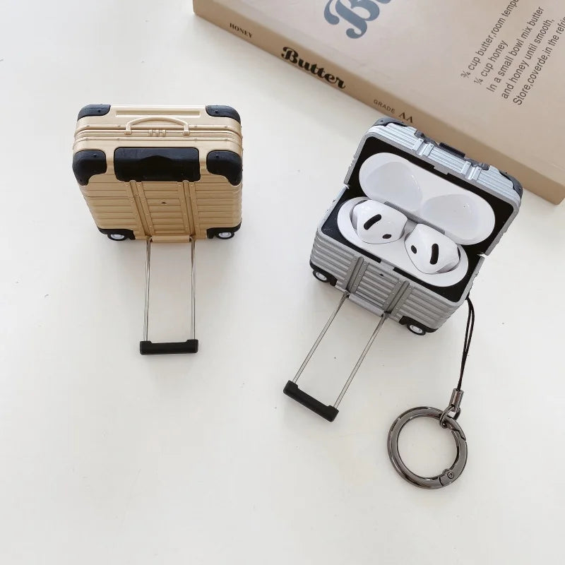 Gold and silver hard-shell suitcase-style cases for AirPods (3rd Gen), featuring retractable handles and keychains.