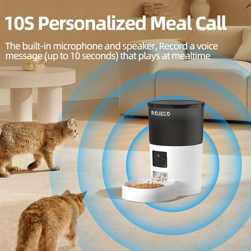Automatic pet feeder with black and white cylindrical design, digital display, and bowl, surrounded by two cats.
