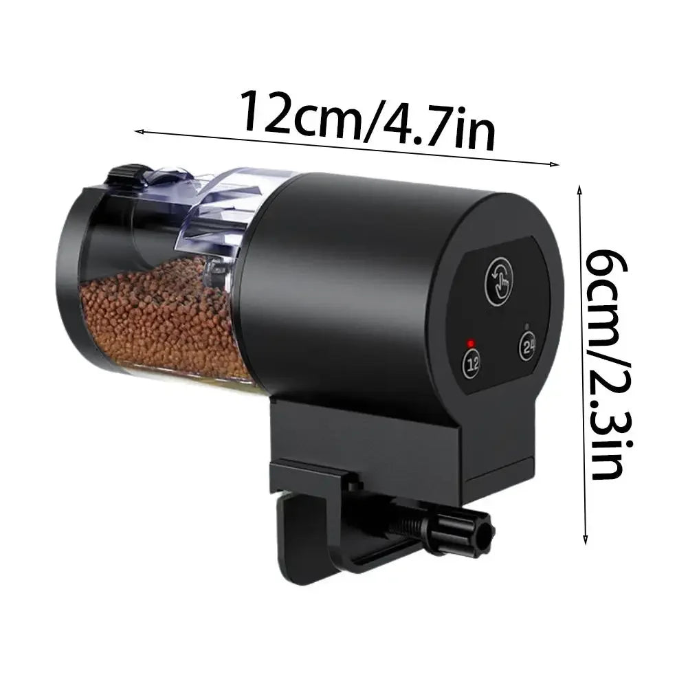 Black automatic fish tank feeder with a clear food container and control panel, showing dimensions of 12cm by 6cm.