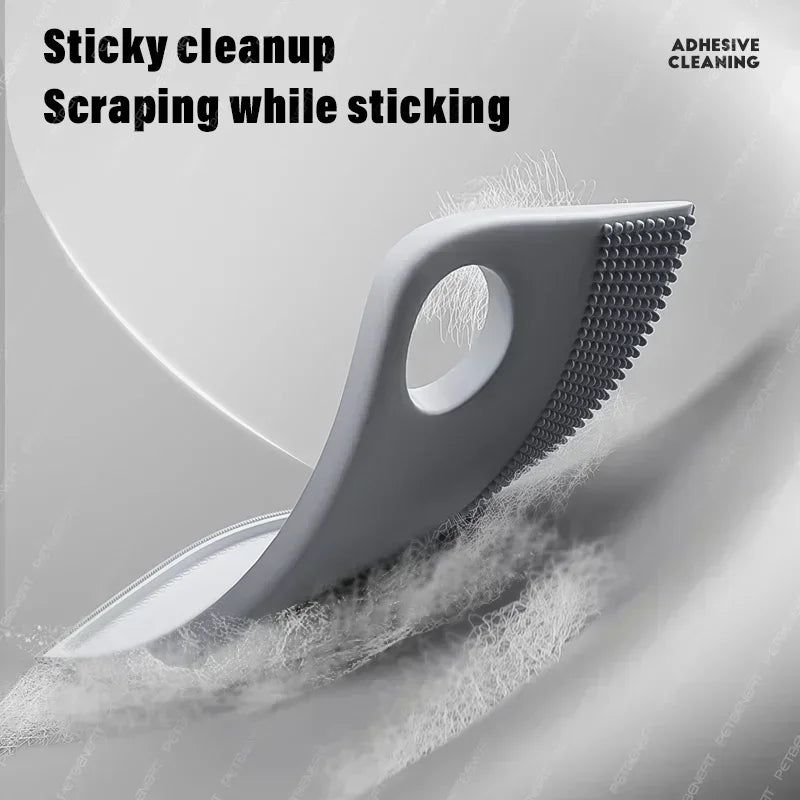 Grey handheld silicone lint scraper with a textured edge for removing pet hair and lint from fabrics.