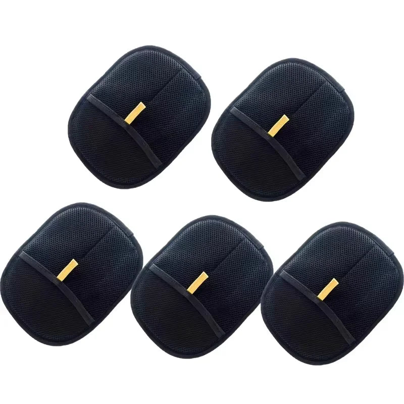 Five black, oval-shaped makeup remover pads with a textured mesh surface and a gold-coloured finger strap.