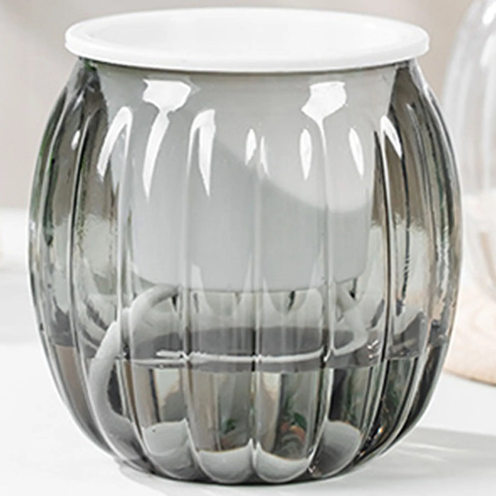 Modern self-watering planter with a ribbed, transparent grey glass outer pot and a white internal basket.