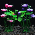 Two artificial lotus plants with pink and purple flowers and bright green leaves, set against a dark aquarium background.