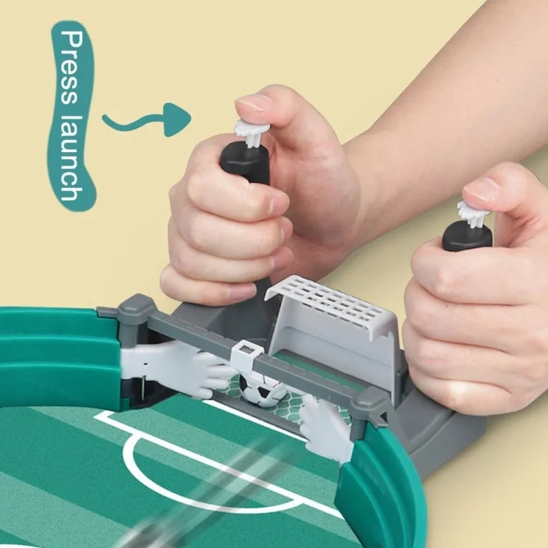 Tabletop football game in green and grey with dual-hand controllers, manual launch buttons, and goal-blocking paddles.