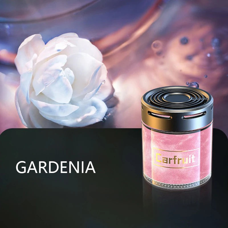 Gardenia-scented cylindrical car air freshener with a metallic black cap and shimmering pink glass body.