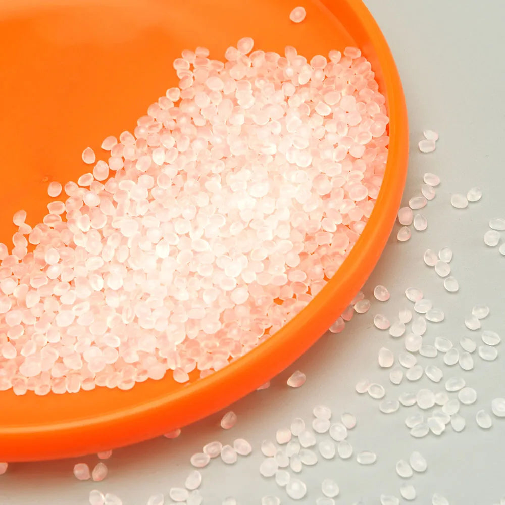 Bright orange dog training disc being filled with translucent, durable polymer pellets.